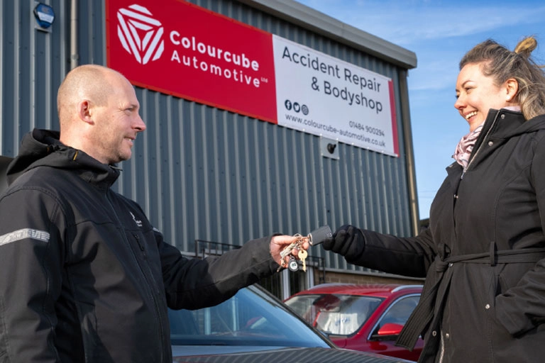 Technician holding car keys with Colourcube branding