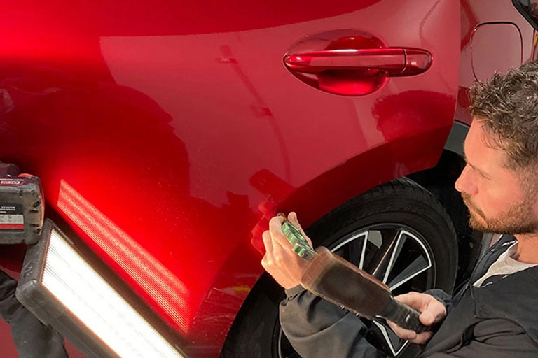 Technician doing paintless dent repair in west yorkshire